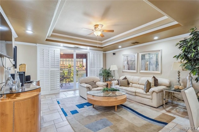 living area with ceiling fan, visible vents, a raised ceiling, and crown molding