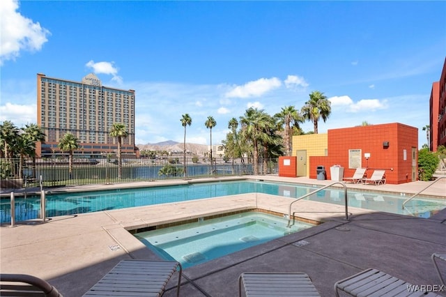 pool featuring a mountain view, fence, a community hot tub, and a patio