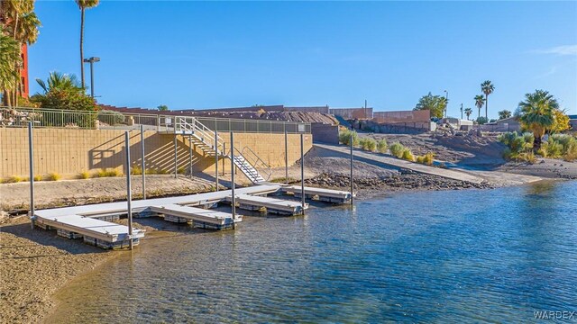 view of dock featuring a water view and fence