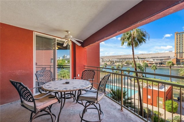 balcony featuring a water view and ceiling fan