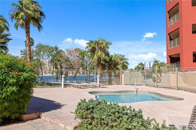 view of pool featuring a patio area, fence, and a swimming pool