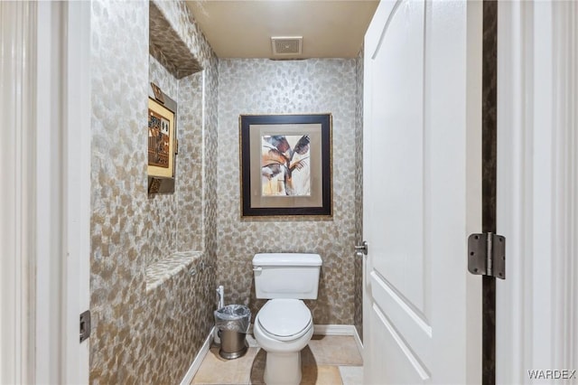 bathroom with baseboards, visible vents, toilet, and wallpapered walls