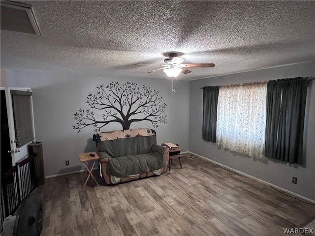 unfurnished room with a ceiling fan, a textured ceiling, baseboards, and wood finished floors