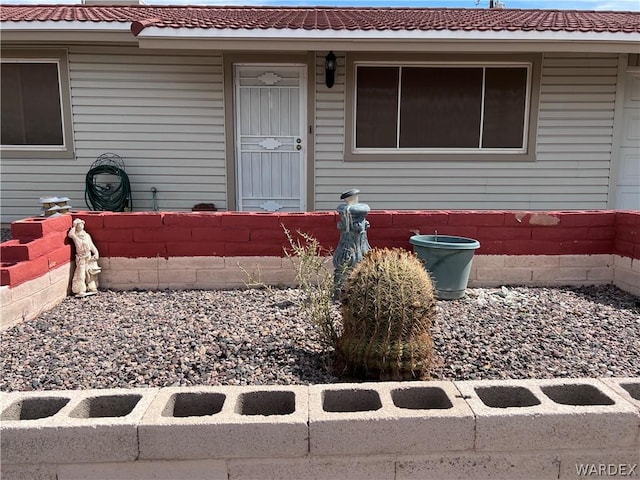 property entrance featuring a tiled roof