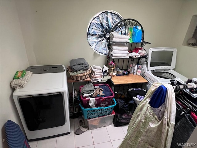 laundry area with laundry area, washer and clothes dryer, and light tile patterned flooring