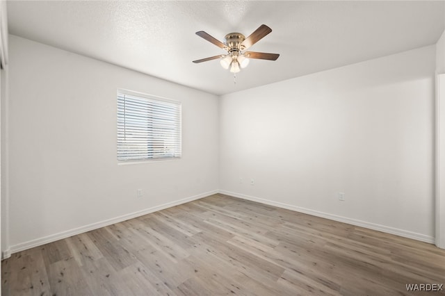 unfurnished room featuring baseboards, a textured ceiling, a ceiling fan, and light wood-style floors