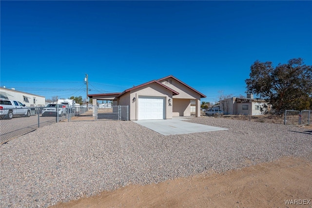 view of front of house featuring an attached garage, driveway, fence, and stucco siding