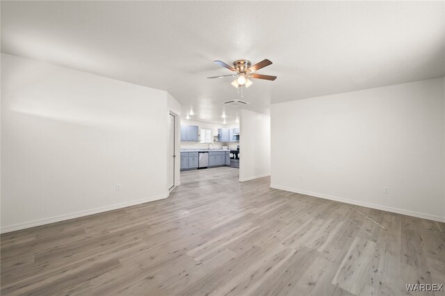 unfurnished living room with a ceiling fan, baseboards, visible vents, and light wood finished floors