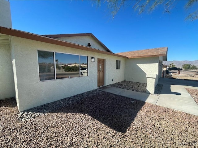 ranch-style home featuring a mountain view and stucco siding