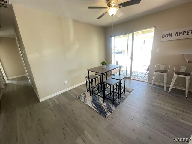 dining space with dark wood-type flooring, visible vents, and baseboards