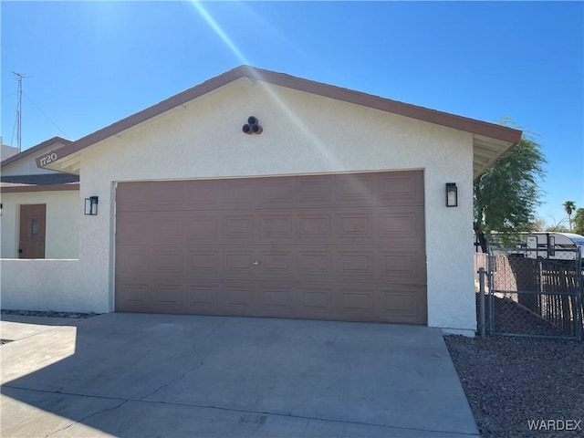 garage with driveway and fence