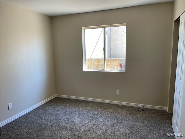 spare room featuring carpet floors and baseboards