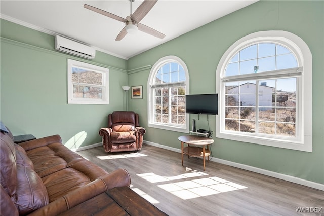 living area featuring baseboards, a wall mounted air conditioner, a ceiling fan, and wood finished floors