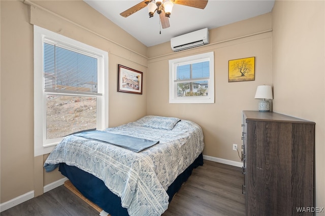 bedroom with ceiling fan, a wall mounted AC, baseboards, and wood finished floors