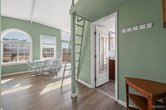 interior space featuring beam ceiling, wood finished floors, and baseboards