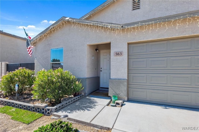 property entrance with a garage and stucco siding