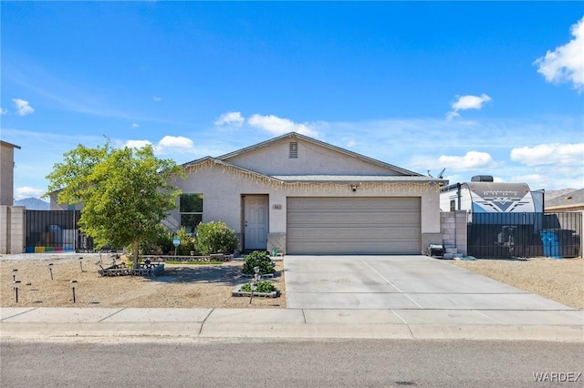 ranch-style house featuring an attached garage, fence, concrete driveway, and stucco siding