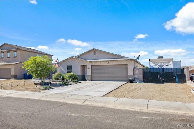 ranch-style house featuring a garage, concrete driveway, fence, and stucco siding