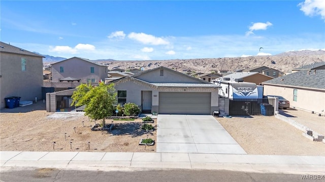 view of front of home with a mountain view, an attached garage, fence, and a residential view