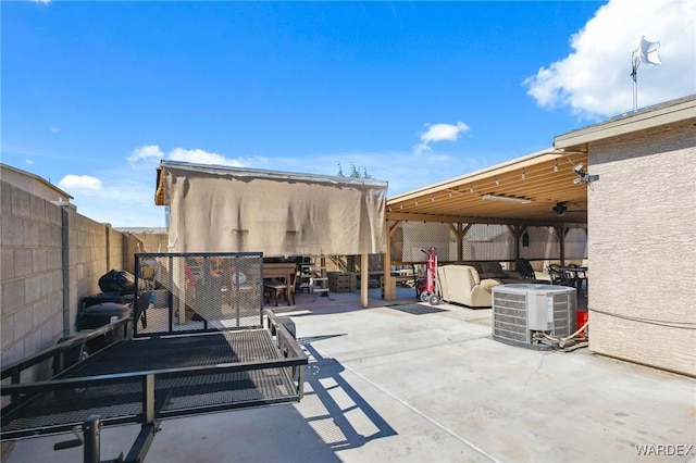 view of patio with outdoor dining space, a fenced backyard, and central AC unit