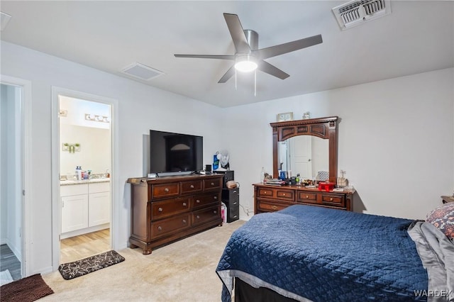 bedroom featuring visible vents, attic access, light carpet, connected bathroom, and ceiling fan