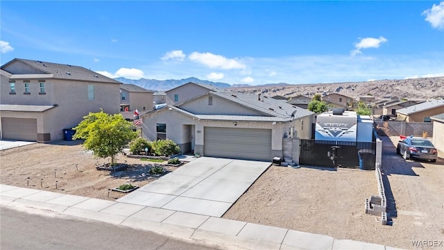 view of front of house with an attached garage, a mountain view, driveway, a residential view, and stucco siding