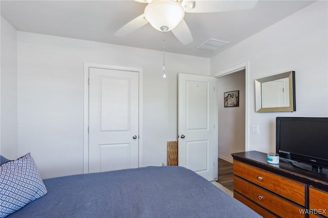 bedroom featuring visible vents, a ceiling fan, and wood finished floors