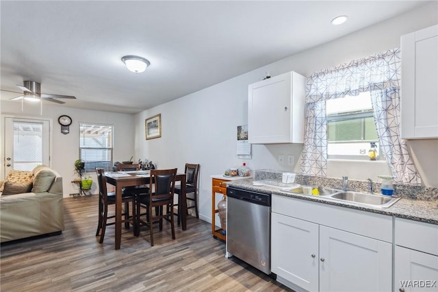 kitchen with white cabinets, a ceiling fan, dishwasher, wood finished floors, and a sink