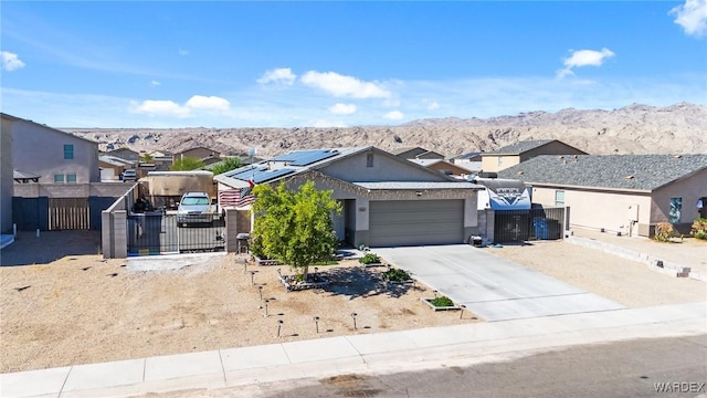 ranch-style house featuring a residential view, concrete driveway, a mountain view, and fence