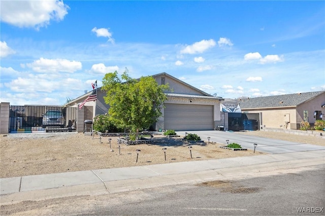 view of front of home featuring stucco siding, concrete driveway, an attached garage, a gate, and fence