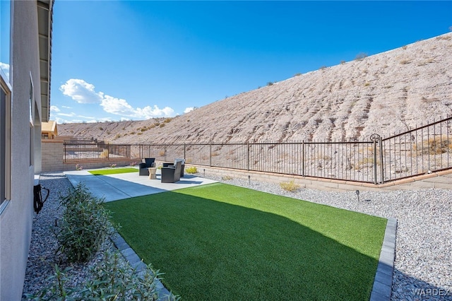 view of yard featuring a patio area, a mountain view, and a fenced backyard