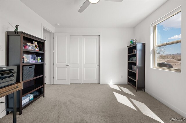 bedroom featuring a closet, a ceiling fan, and light colored carpet