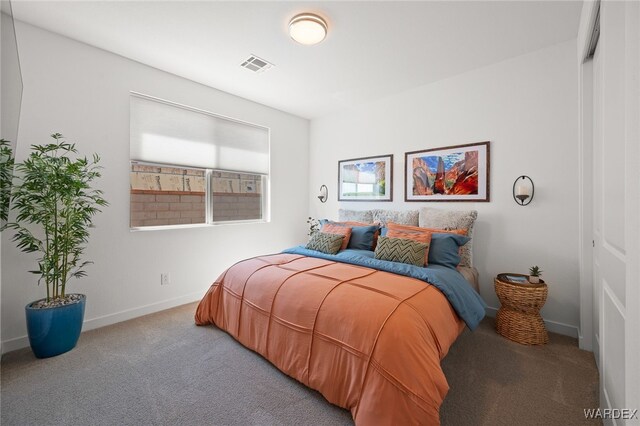 carpeted bedroom with a closet, visible vents, and baseboards