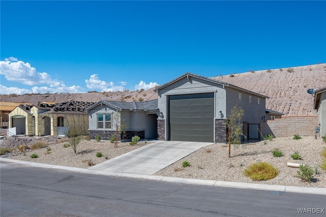 view of front facade featuring a garage, stone siding, driveway, and stucco siding