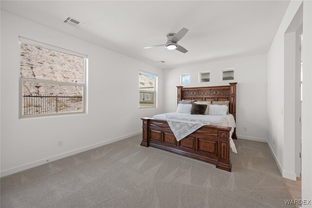 bedroom featuring light colored carpet, ceiling fan, and baseboards