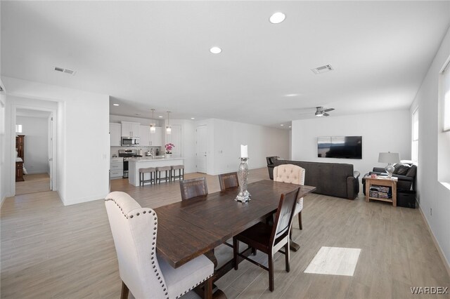 dining area with light wood-type flooring, baseboards, visible vents, and recessed lighting