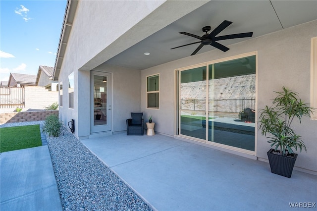 view of patio with fence and a ceiling fan