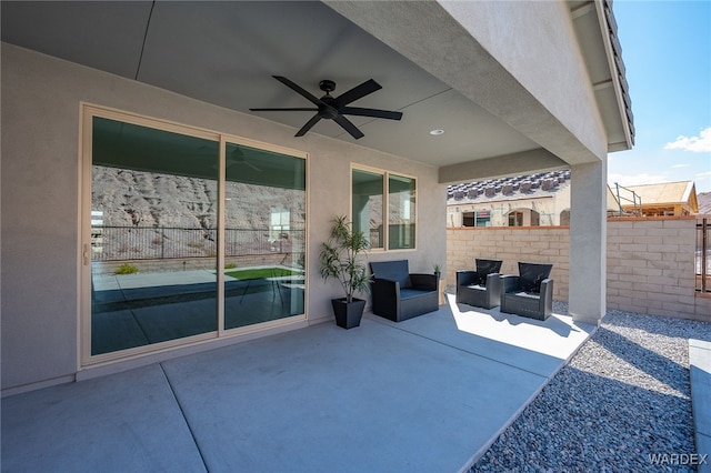 view of patio / terrace featuring fence, an outdoor living space, and a ceiling fan