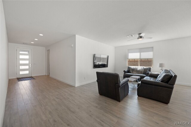 living area with recessed lighting, visible vents, light wood-style flooring, ceiling fan, and baseboards