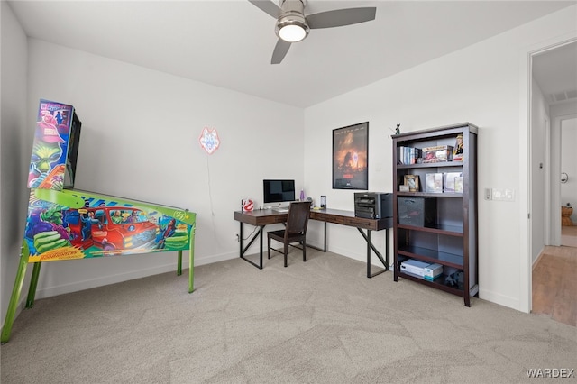 home office with ceiling fan, visible vents, baseboards, and light colored carpet