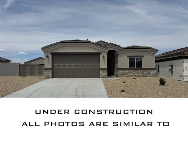 2206 E Hutch St, Fort Mohave, AZ 86426 - prairie-style home featuring stone siding, a garage, concrete driveway, and stucco siding