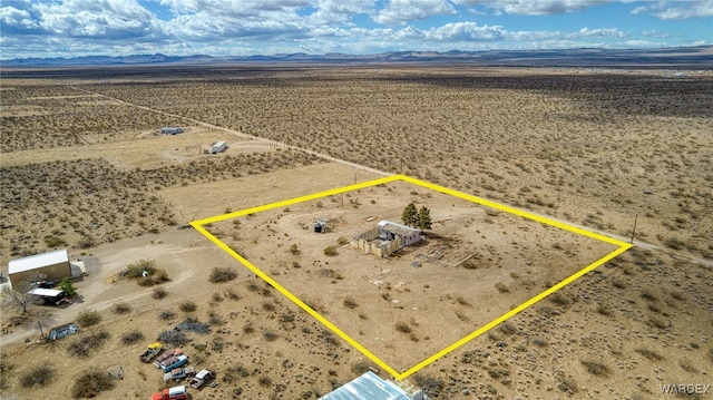 drone / aerial view featuring a mountain view, a desert view, and a rural view