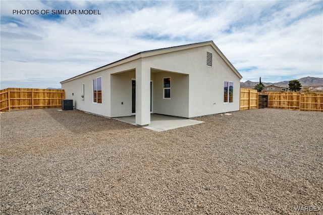 rear view of property with central AC, a patio area, stucco siding, and a fenced backyard
