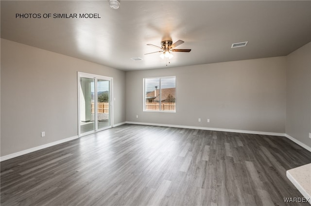 unfurnished room with baseboards, ceiling fan, visible vents, and dark wood-style floors