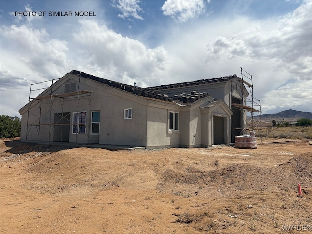 view of home's exterior with stucco siding, a tiled roof, and a mountain view