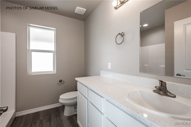 full bathroom with toilet, baseboards, vanity, wood finished floors, and a shower