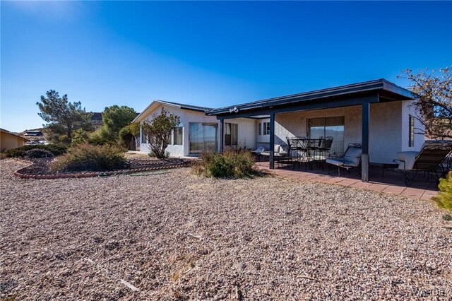 view of front of home with stucco siding and a patio