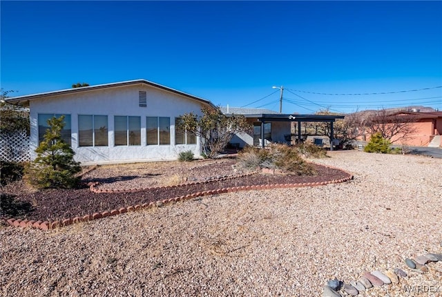 back of house featuring driveway and stucco siding