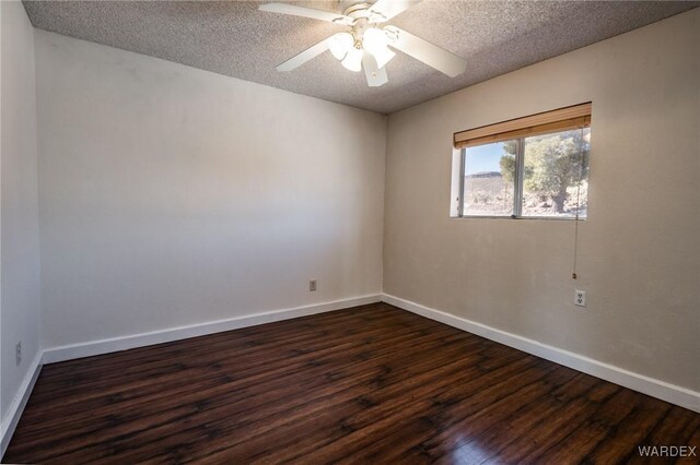 unfurnished room with dark wood-style floors, a ceiling fan, baseboards, and a textured ceiling