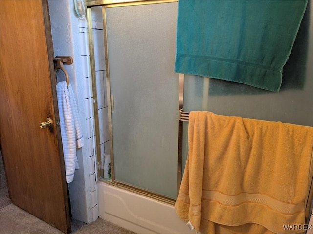 bathroom featuring combined bath / shower with glass door